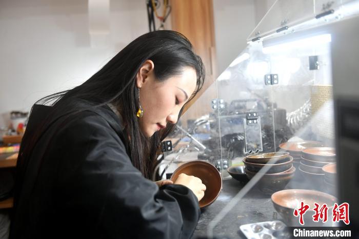 在唐潔工坊內，“90后”文物修復師瞿汕正低頭忙碌。　呂明 攝